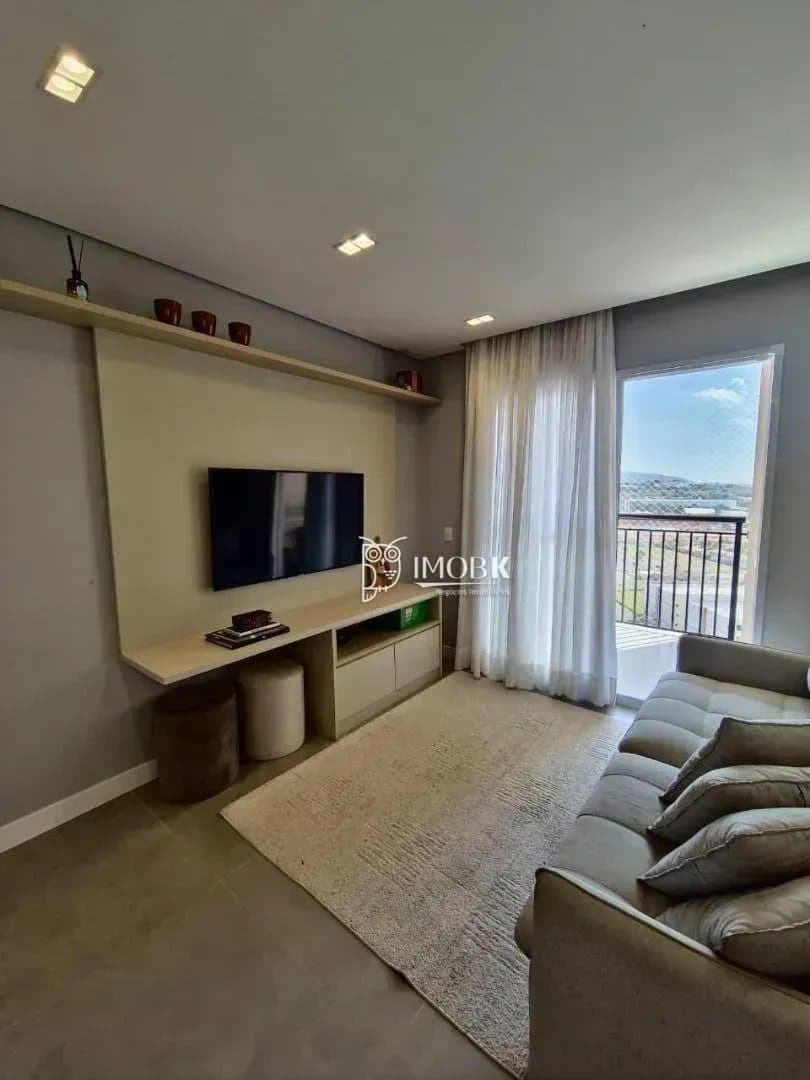 Sala de estar com sofá, painel para TV e rack com armários.