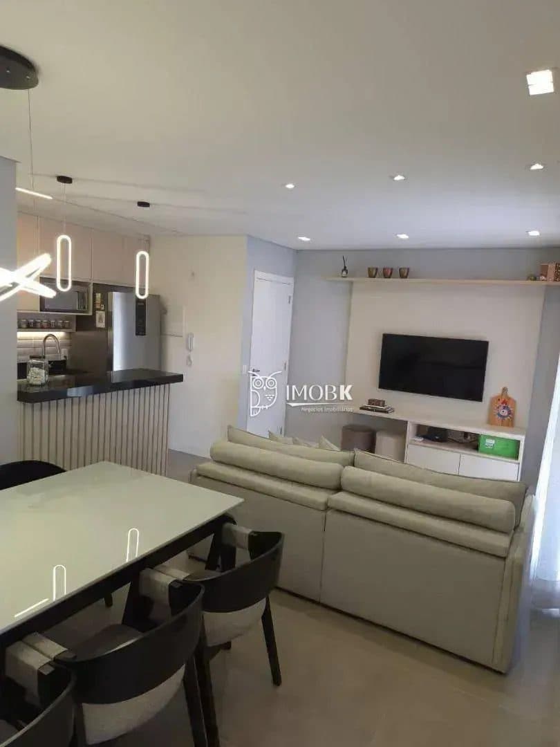 Sala de estar e jantar integrada com mesa, cadeiras e sofá.