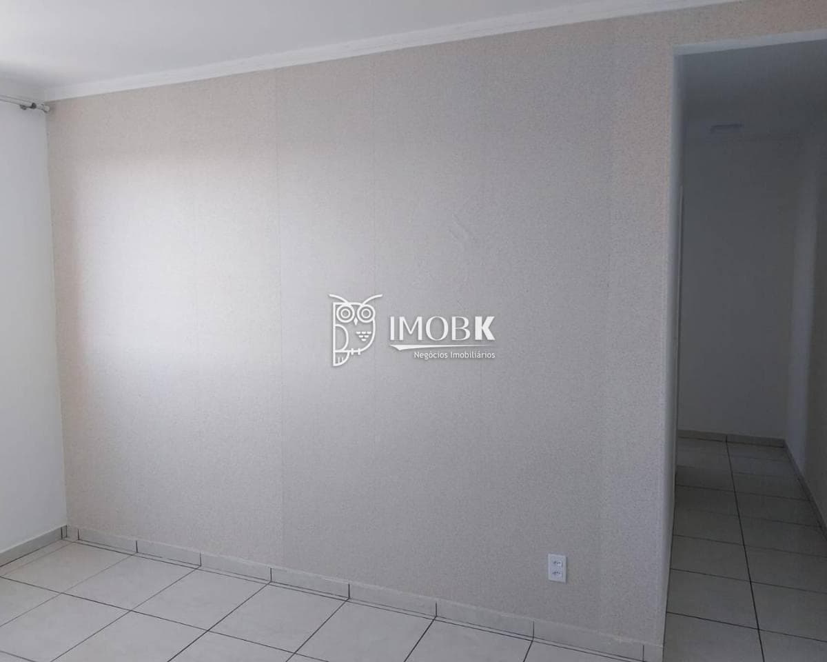 Sala de estar com parede revestida em textura e corredor de circulação ao fundo.