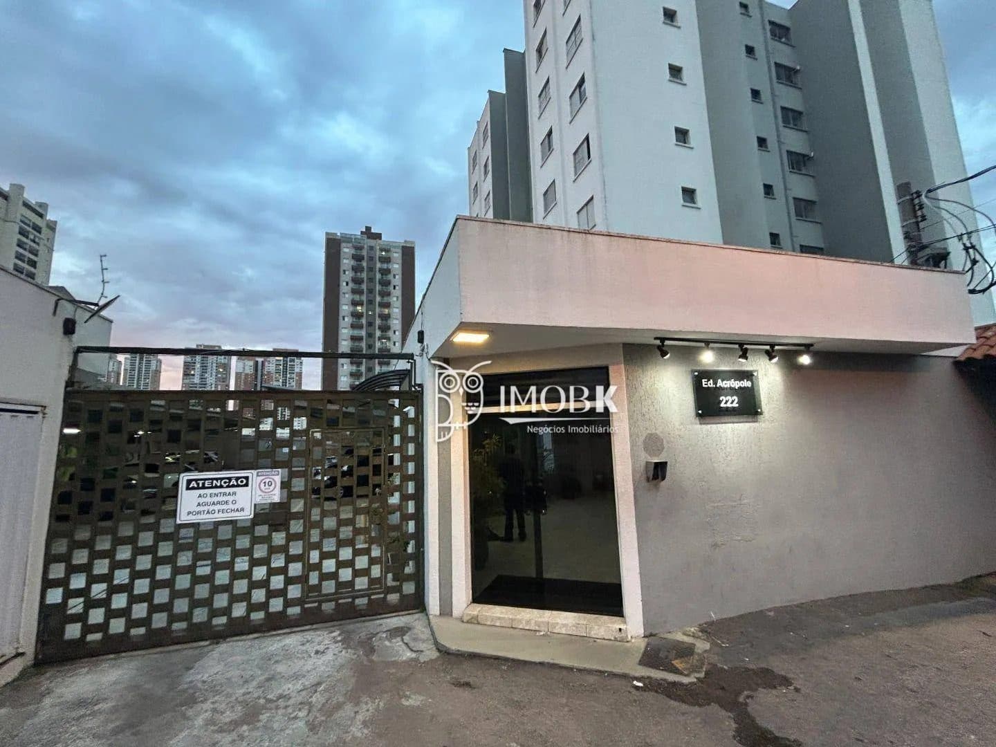 Fachada da entrada do edifício com portão de garagem e guarita