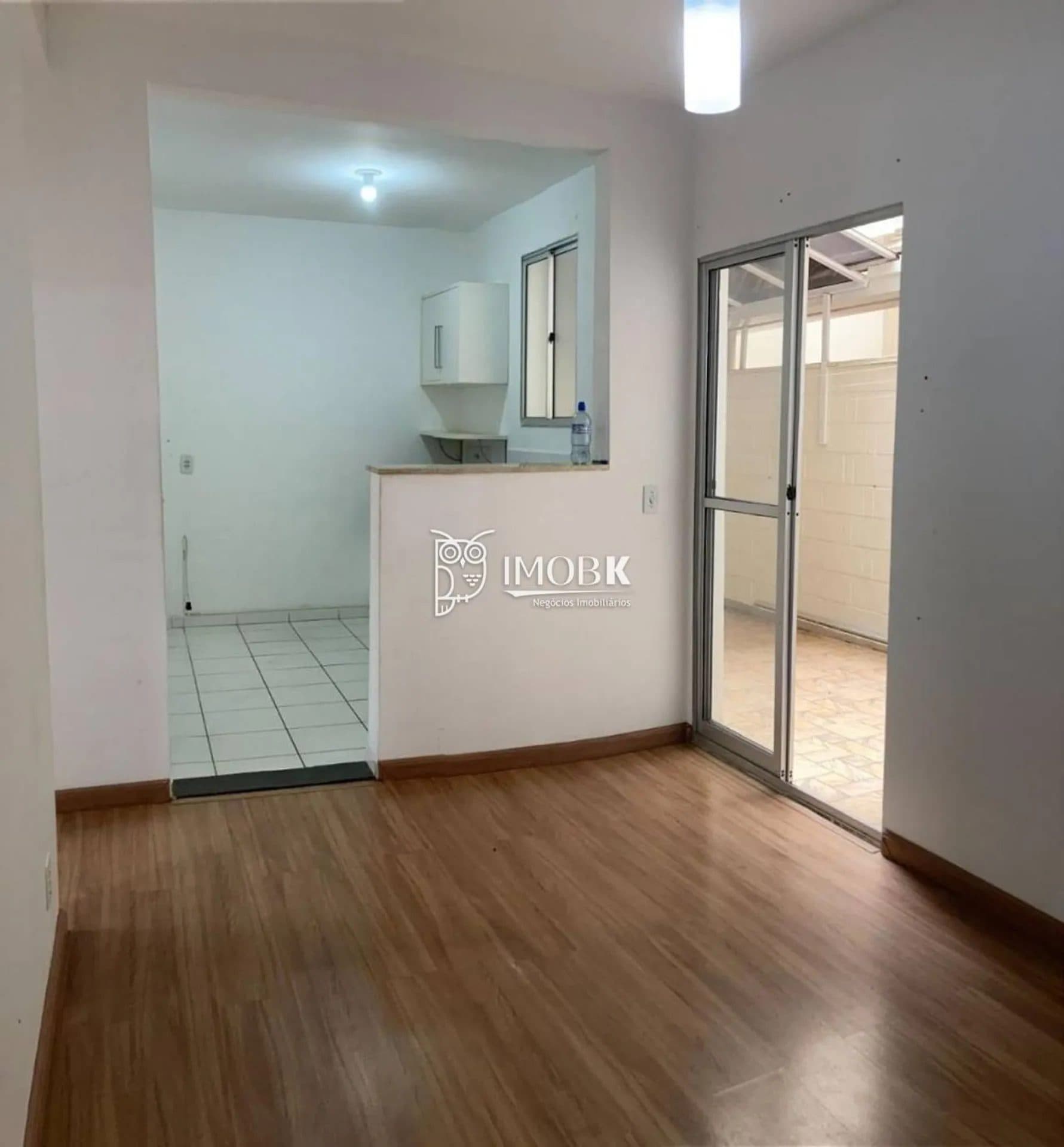 Sala integrada com passagem para cozinha e porta de correr de vidro com acesso externo.